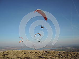 People paragliding in a free fly in Europe in Alps mountains with blue sky in the background
