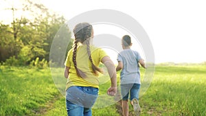 People in park. Happy family children a kid together run in park at sunset silhouette. Brother and sister run. happy