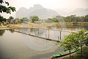 people passing bamboo bridge on limestone mountain background