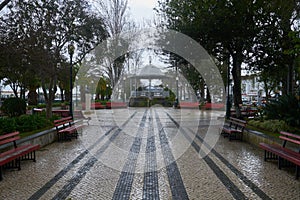 People passing on a street in Tavira, Algarve with a Coreto, in Portugal