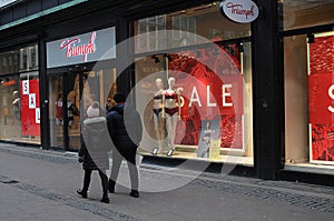 PEOPLE PAST BY SALE SIGN IN TUMPH LINGERIE STORE