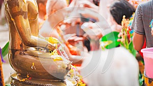 People pay homage to Buddha images and monks during the Songkran festival in Thailand