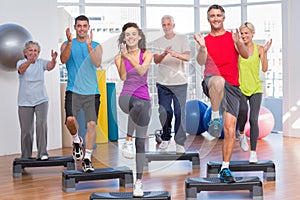 People performing step aerobics exercise in gym