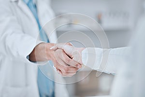 People, pharmacist and handshake in meeting, teamwork or agreement together for deal at pharmacy. Closeup of medical or