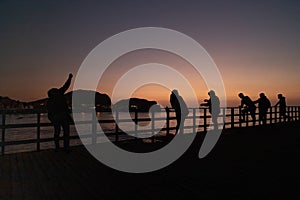 People on pier on sunset