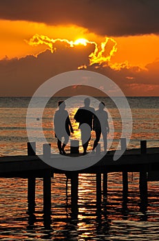 People on pier at sunset