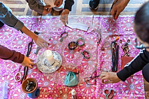 People placing objects on a blanket with a candle for a New Year's Eve Ritual of Intentions photo