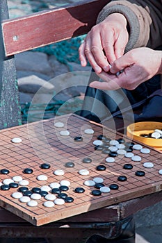 People playing chinese chess (go), on a bench