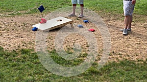 People playing the corn hole game with red and blue throwing corn filled bags recreational team sport