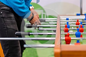 People playing foosball table soccer. Team sport, table football players. Competitive table game