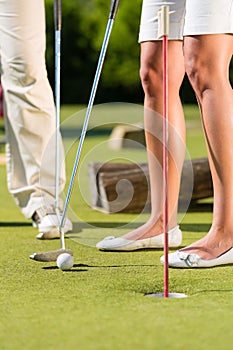 People playing miniature golf outdoors