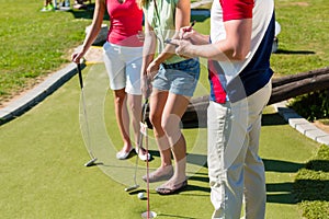 People playing miniature golf outdoors