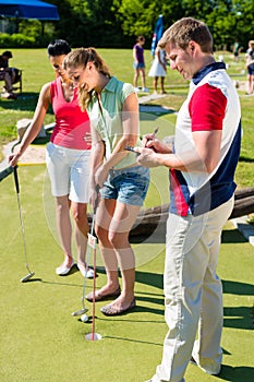 People playing miniature golf outdoors