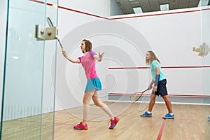 People playing squash enjoying recreational pursuit at indoor training club