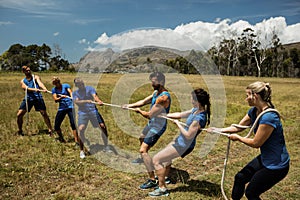 People playing tug of war during obstacle training course