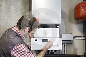 Plumber repairing a condensing boiler photo