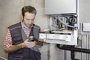 Plumber repairing a condensing boiler photo