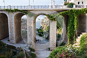 People on the Ponte Lama Monachile bridge in Polignano a Mare, Italy.