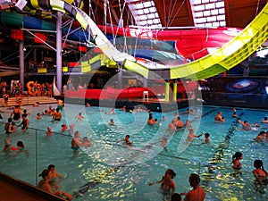 People in the pool with thermal water and giant slide