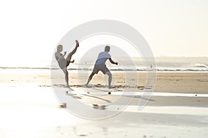 People practicing capoeira martial art on beach