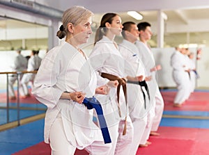 People practicing taekwondo and warming up for training while standing barefoot