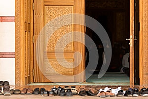 People praying in a mosque. Shoes in front of the mosque photo