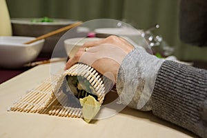 People preparing a rool maki `nori maki zushi`