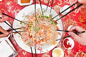 People preparing to toss yusheng or yee sang, a dish consumed during Chinese New Year for luck and prosperity