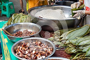 People preparing ZhongZi - traditional Chinese rice dish in bamboo leaves