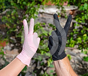 People in protective gloves showing Victory Peace sign