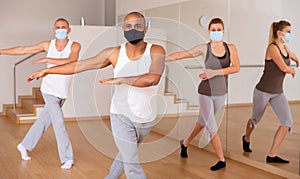 People in protective masks learning swing steps at class