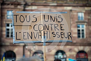 People protesting against the war with text in french : Tous unis contre l`envahisseur, in english : all united against the photo
