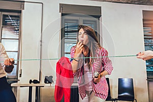 People pulling rope in office, funny teambuilding activity