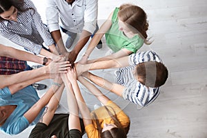 People putting hands together indoors