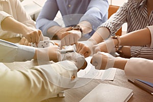 People putting hands together at table. Unity