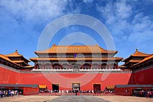 People queuing in front of one of the internal red colored gates of the Palace Museum, known as the Forbidden City, in