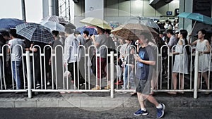 People in rain in beijing wudaokou station