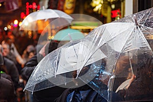 People with rain umbrellas in the rainy city