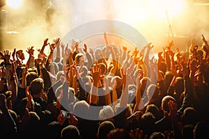 People with raised hands at a public event. Gathering in concert hall