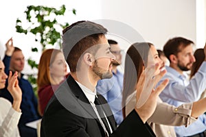 People raising hands to ask questions at business training