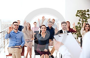 People raising hands to ask questions at business training