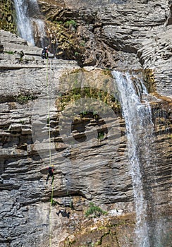 People rappelling in an impressive waterfall