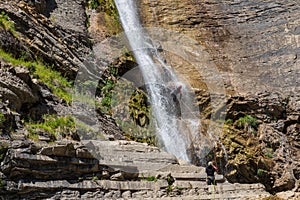 People rappelling in an impressive waterfall