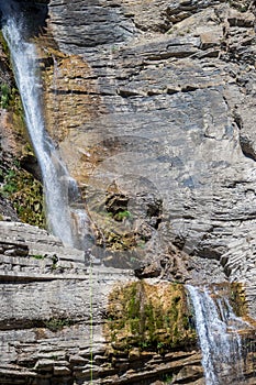 People rappelling in an impressive waterfall