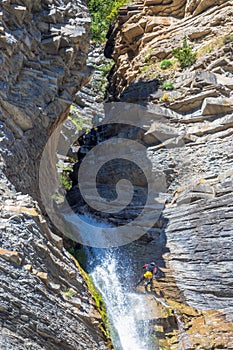 People rappelling in an impressive waterfall