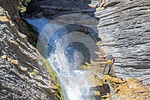People rappelling in an impressive waterfall