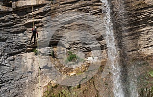 People rappelling in an impressive waterfall