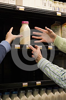 People reaching for milk