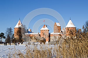 People recreate Trakai fort snow frozen lake reeds