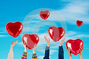 People with red heart balloons